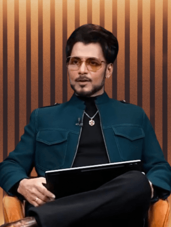 अनुपम मित्तल गहरे रंग का जैकेट और धूप का चश्मा पहने कुर्सी पर बैठकर बातचीत करते हुए।