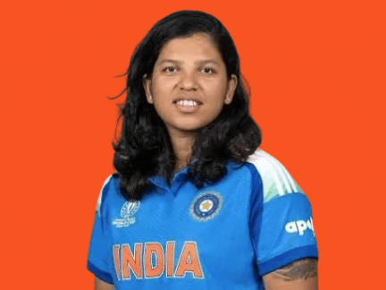 नारंगी पृष्ठभूमि के सामने नीली भारतीय महिला क्रिकेटर जर्सी पहने ऋचा घोष का पोर्ट्रेट, जिनके कंधों तक काले बाल हैं और वो सामने देख रही हैं।