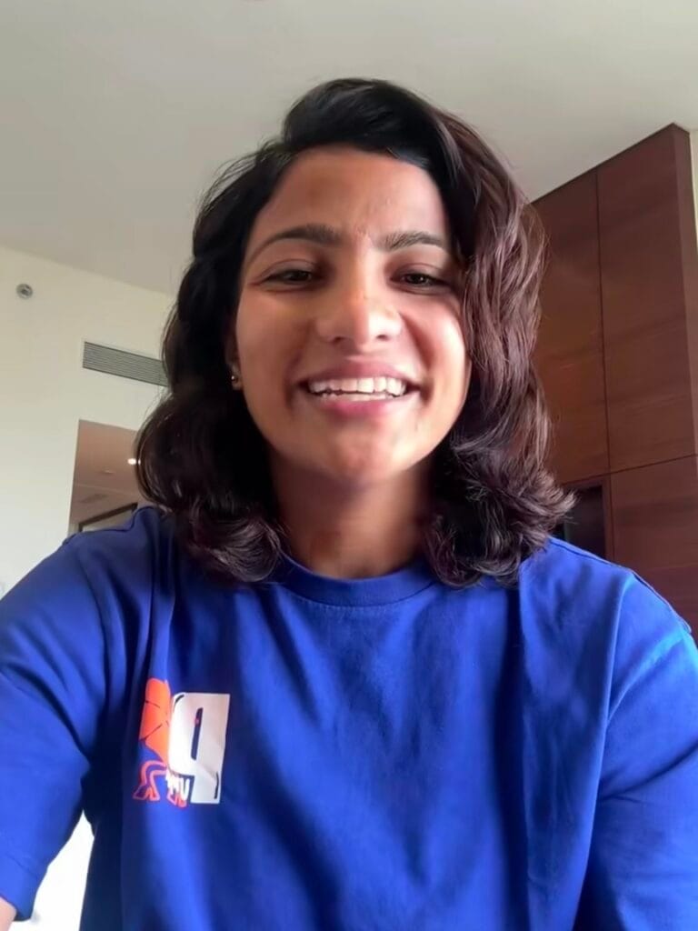 भारतीय महिला क्रिकेटर स्नेह राणा की मुस्कुराती हुई नीले टीशर्ट में छवि